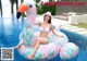 A woman in a white bikini sitting on an inflatable flamingo.