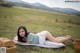 A woman laying on a blanket in a field.