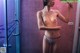 A naked woman taking a shower in a bathroom.