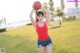 A woman holding a basketball in a field.