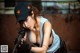 A woman holding a rifle and wearing a baseball cap.